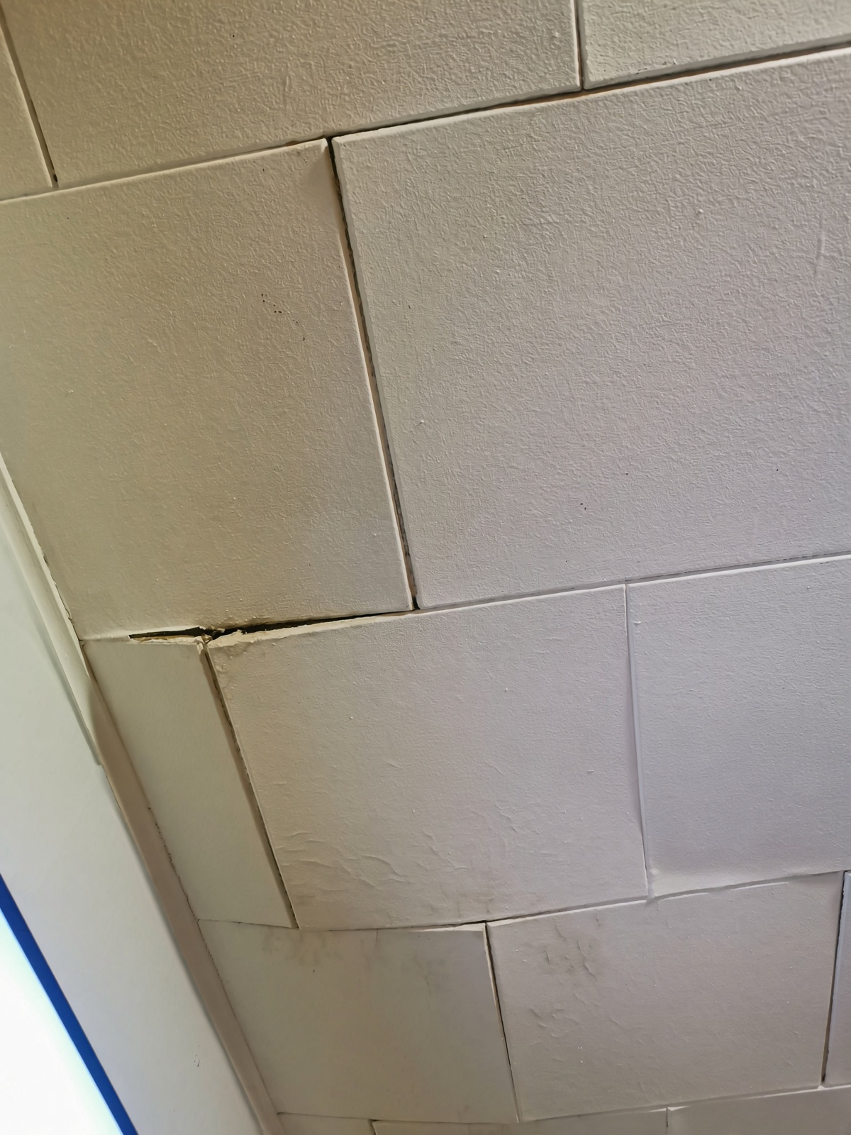 Sagging drywall ceiling section in a San Diego room before re-fastening